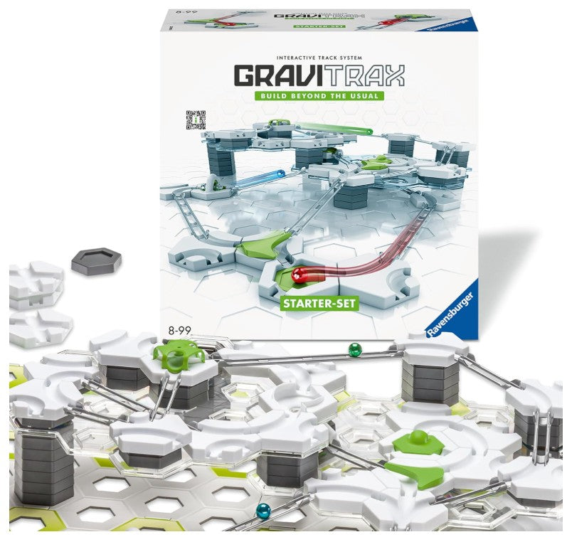 Ravensburger GraviTrax interactive track system starter set, showing the product box, loose gray track pieces, and a built section of the white, gray, and green marble run tracks with marbles on a white background.