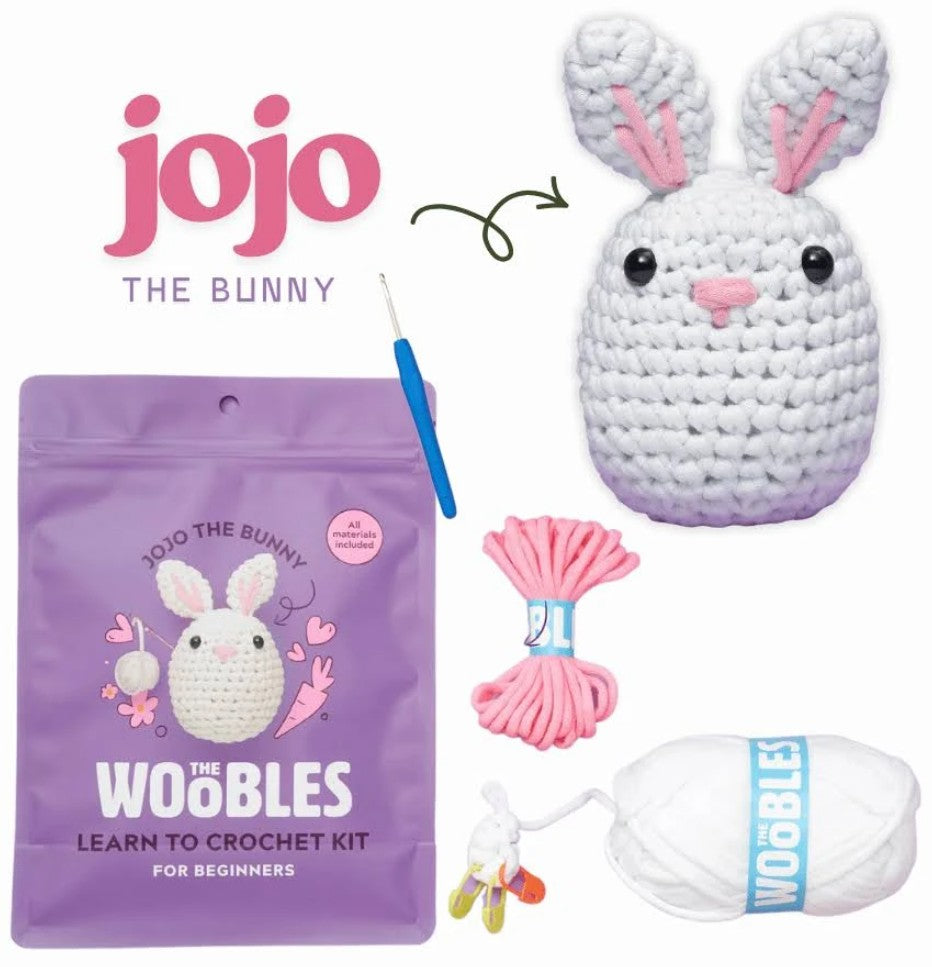 Jojo the Bunny Learn to Crochet Kit by Jojo, featuring a purple pouch, white yarn, pink thread, a blue crochet hook, and a finished crocheted bunny, all arranged on a white background.