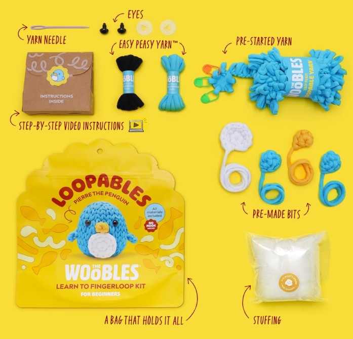 Loopables 'Wobbles' Learn to Finger Loop Kit shown as a flat lay on a bright yellow background, including a yarn needle, easy peasy yarn, pre-started yarn, finger loops, pre-made bits, stuffing, and the branded package.
